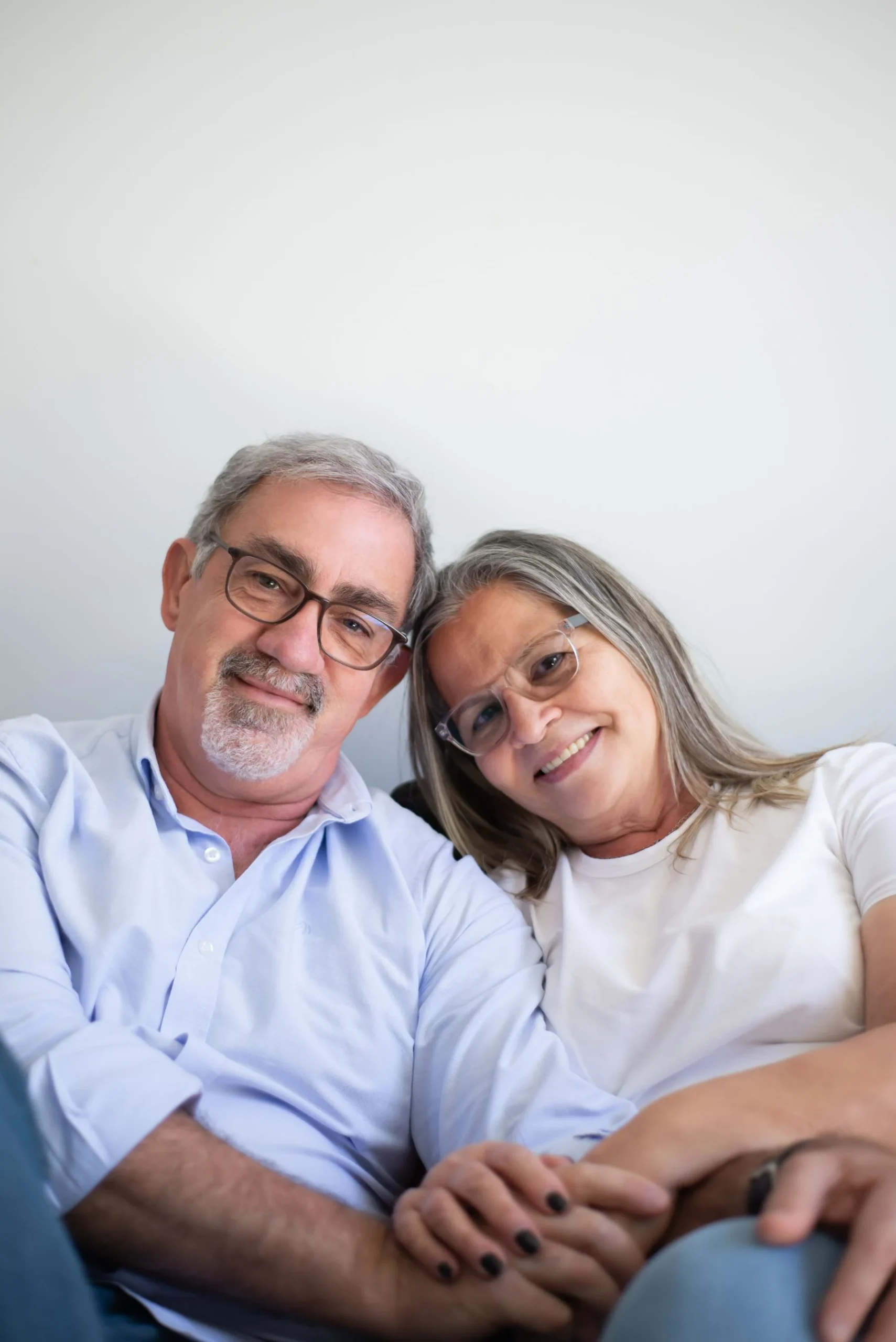 A smiling older couple sitting comfortably together at home